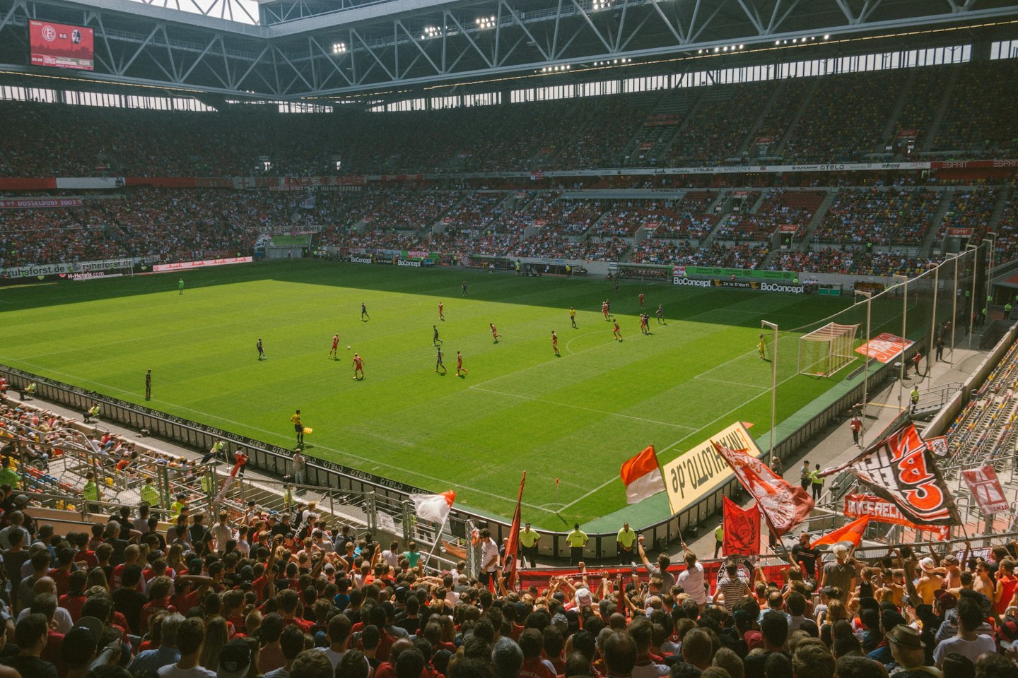 Soccer players compete on a field in a crowded stadium.