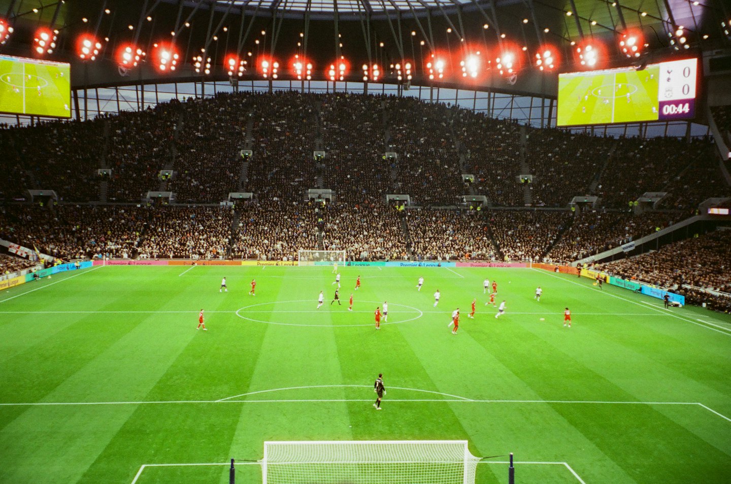 Soccer players compete on a stadium pitch before a large crowd.