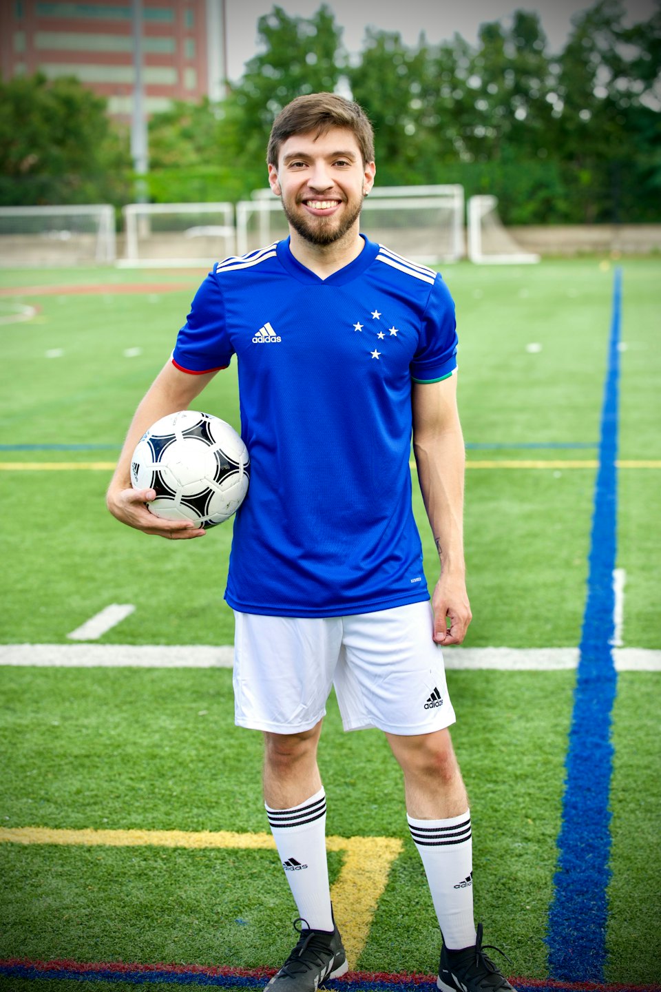 Soccer player in a blue jersey holding a ball.