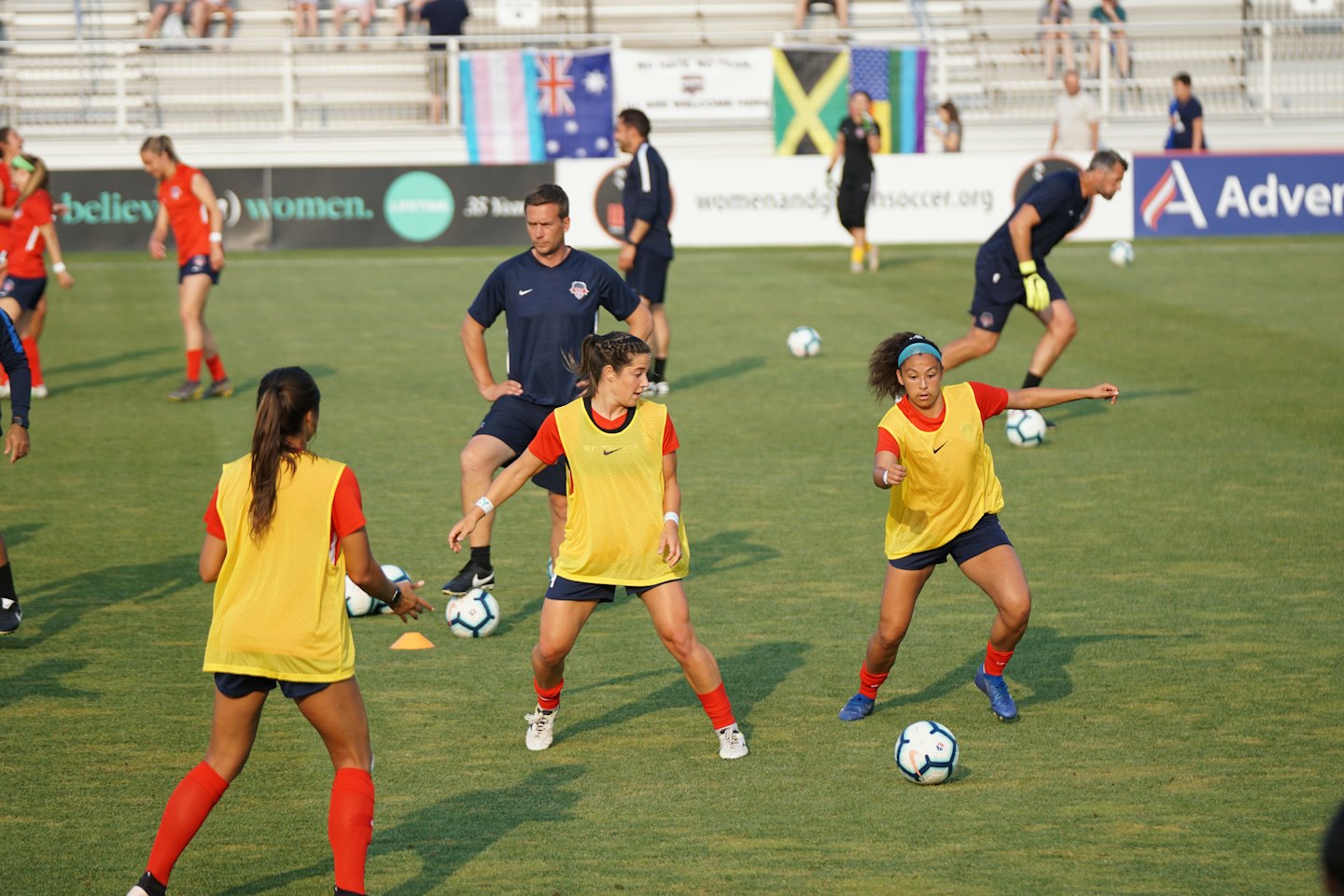Soccer players and their coach practicing on a grassy field.