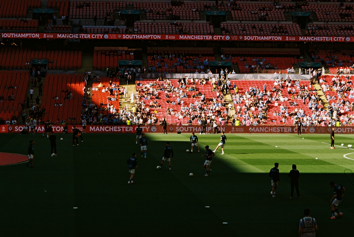 Football players warm up on a field before a match.